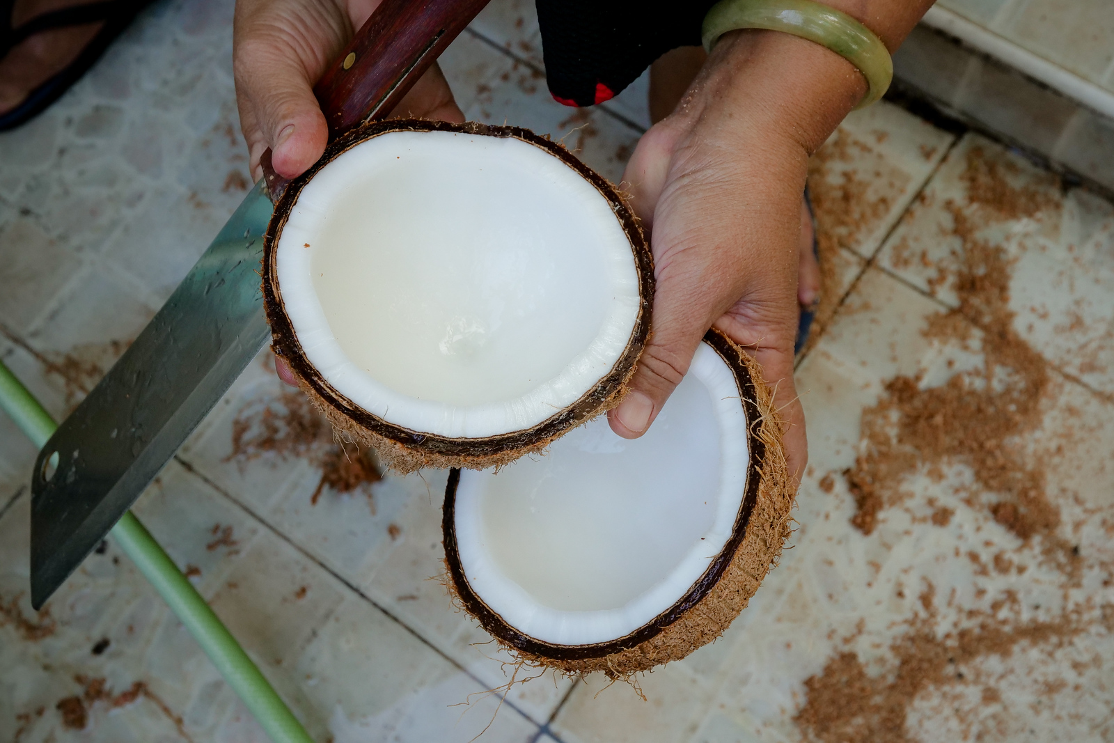 Breaking the coconut cleanly in halves